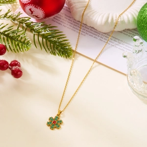 Vue détaillée du collier flocon de neige doré avec émail vert et pierre centrale rouge