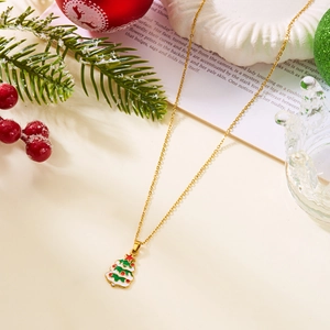 Détail du collier de Noël doré avec pendentif sapin en émail coloré sur décor de fête