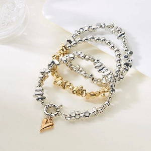Dreiteiliges geschichtetes CCB Perlenarmband-Set in Silber und Gold mit Herzanhänger