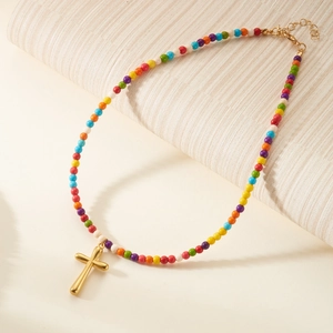 Close-up of a colorful beaded necklace with a golden cross pendant and OT clasp detail