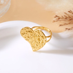 Detailed close-up of a gold heart ring with hammered texture and adjustable double band