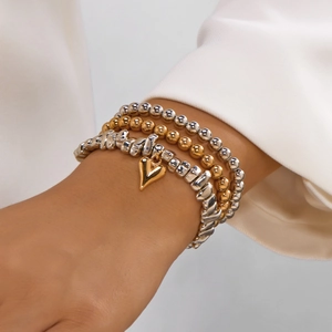 Details von geschichteten Silber- und Gold-CCB-Perlenarmbändern mit Herzanhänger-Set