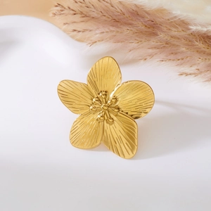 Detailed macro view of a golden five-petal flower ring with textured petals and center beads