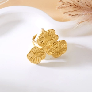 Detailed macro view of three golden flower embossed motifs on a minimalist adjustable ring