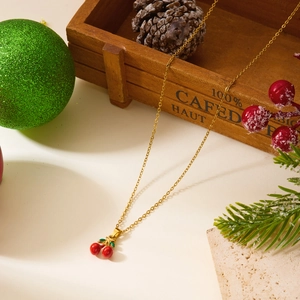 Gros plan détaillé d'un collier pendentif cerise dorée avec décorations de Noël