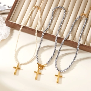 Three natural stone beaded cross necklaces on a wooden velvet jewelry display tray