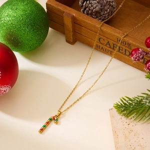 Détail du collier canne de Noël avec émail rouge et vert sur une chaîne dorée