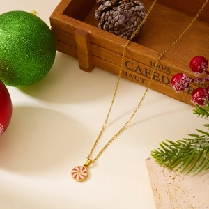 Détail du collier doré avec pendentif spirale rouge et blanc au motif de Noël