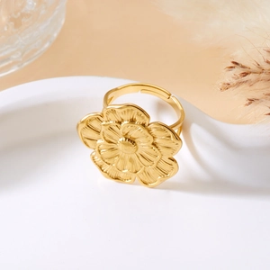 Macro shot of an adjustable golden ring featuring an intricate layered flower petal design