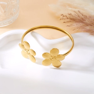 Detailansicht eines goldenen Edelstahl-Armreifs mit gebürsteten Blumenmustern