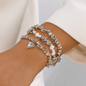 Mehrlagiges Perlenarmband-Set mit Silberherz-Anhänger und Barockperlen an Model
