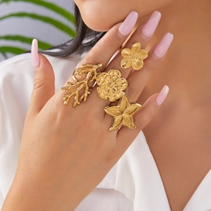 Gold adjustable ring set with floral, starfish and coral designs on model hand