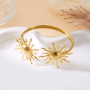 Detailansicht eines goldenen Edelstahl-Armreifs mit hohlem Sonnenstrahl-Muster