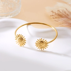 Nahaufnahme der goldenen Edelstahl-Manschette mit geprägten Sonnenblumen-Details
