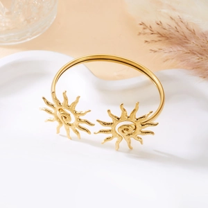 Detail eines goldenen Armreifs mit doppelten Sonnenmotiven und strukturierten Spiralen