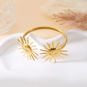 Detailansicht des goldenen Armreifs mit Sonnenprägung und Gravur auf weißem Hintergrund