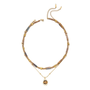 Detail of layered stainless steel necklace with tiger eye beads and waterdrop pendant