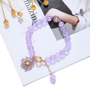 Lila Kräuselperlen-Armband mit Gänseblümchen-Anhänger auf schlichtem weißem Hintergrund