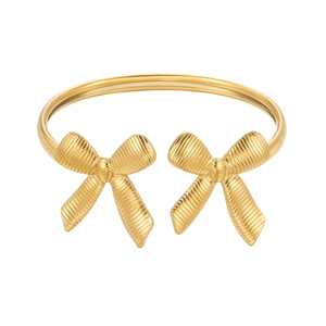 Detail of gold bow cuff bracelet featuring micro-etched striped texture and polished finish