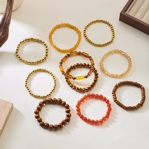 Detail of assorted bohemian beaded stretch bracelets with gold, amber, and marble textures