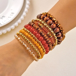 Detail of layered bohemian stretch bracelets with colorful beads and golden accents