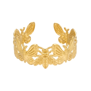 Macro shot of gold-plated bee relief pattern on an adjustable open cuff bracelet