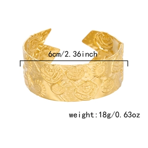 Detail of 6cm diameter gold wide open bangle featuring relief sunflower patterns