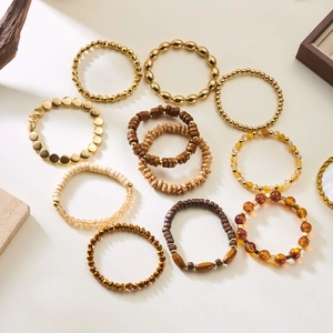 Detail of bohemian stretch bracelets with gold beads, wooden slices and amber crystals