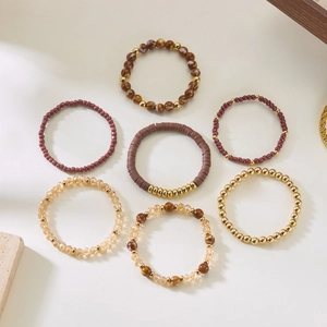 Detail view of 7-piece Bohemian beaded stretch bracelets in brown and gold tones