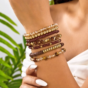 Detail of 8-piece bohemian beaded stretch bracelet set with amber and gold tones