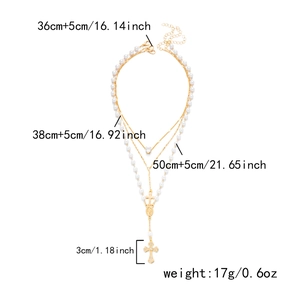 Detailansicht der mehrlagigen Kette mit Herzanhänger, Perlen und einem Diamantkreuz