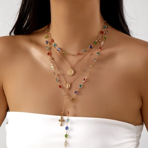 Bohemian gold layered necklace with colorful beads and cross pendant on model