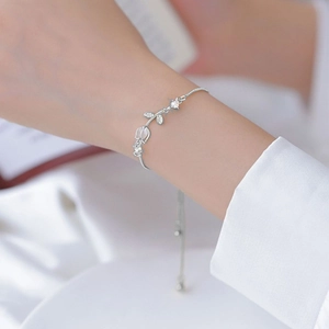 Close-up of tulip flower charm with opal and adjustable silver snake chain on wrist
