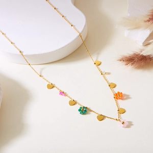 Detail of gold-plated stainless steel necklace with colorful beaded flowers and heart charms