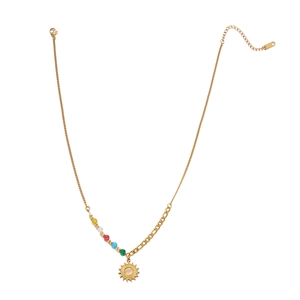 Detail of gold sun pendant necklace with five colored beads and asymmetric steel chain link