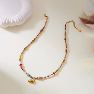 Detail of bohemian necklace with natural stones and gold hollow elephant pendant