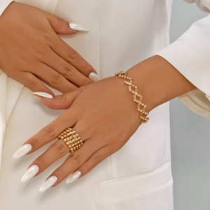 Makroaufnahme von Gold-Strasssteinen einziehbarem magischem Ring und Armband Schmuckset