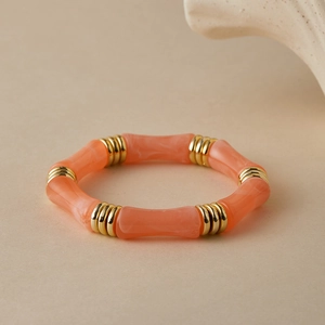 Dettaglio del bracciale a bambù in acrilico marmorizzato rosa con distanziatori dorati