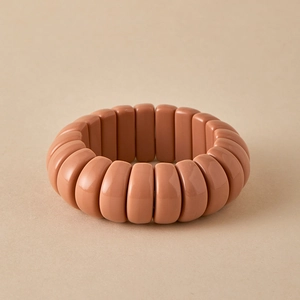Close-up of wide stretch beaded bracelet with peach resin beads and elastic cord detail