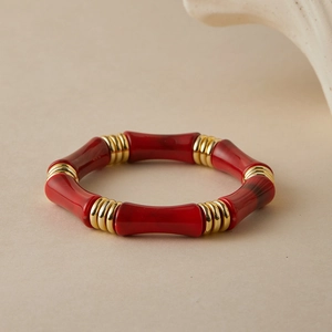 Dettaglio del bracciale a perline rosse stile bambù con distanziali dorati e resina