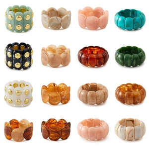 Vue détaillée de bracelets en résine acrylique colorée avec clous dorés et motifs marbre