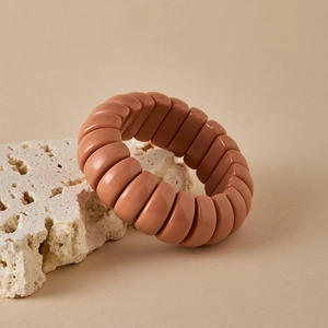 Macro detail of elastic stretch bracelet with polished brown caramel resin beads