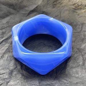 Dettaglio macro del bracciale esagonale in resina con trama marmorizzata blu e design spesso