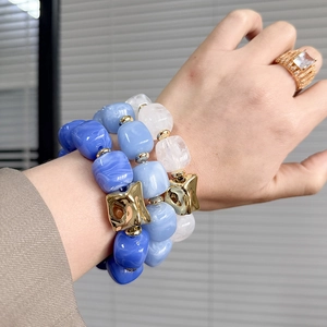 Three-piece set of blue marble beaded bracelets with gold charms and a zircon ring
