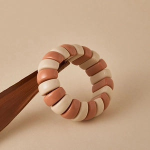 Close-up of color-block beaded bracelet with glossy beige and brick red rectangular beads