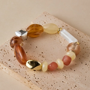Detail of beach style bracelet with leopard print and amber beads on stone base