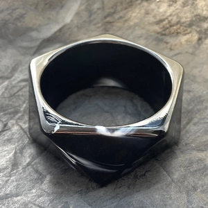 Macro di un anello esagonale geometrico in nero lucido con un design moderno e minimale
