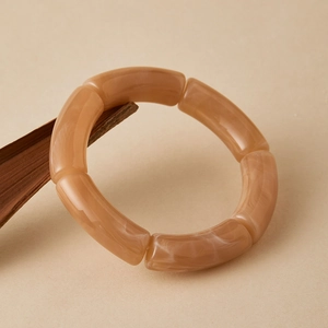 Macro-opname van amberkleurige hars bamboe armband met witte marmeren aders op hout