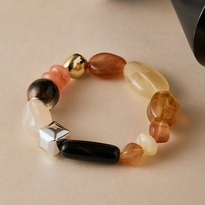 Macro shot of colorful irregular acrylic beads bracelet with gold and silver metallic accents
