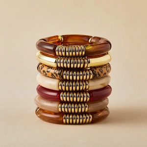 7-piece stackable bracelet set featuring amber resin and golden curved tube beads